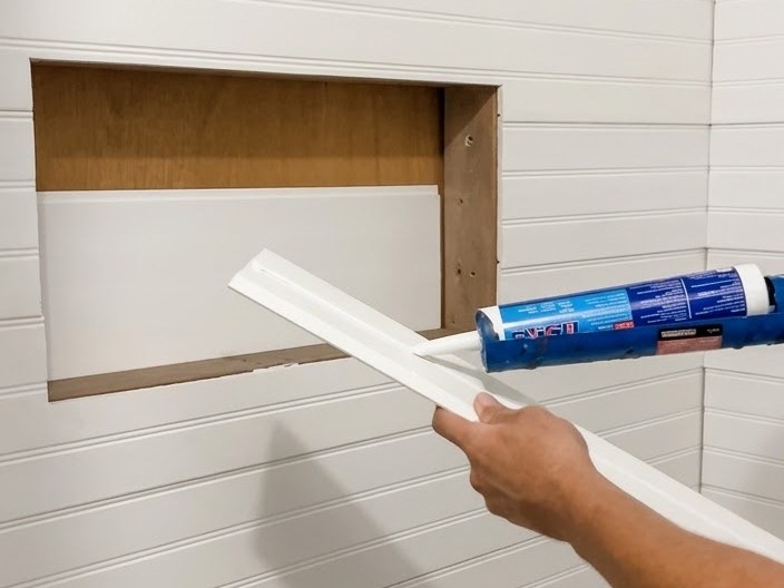 Applying sealant to trim for a shower niche