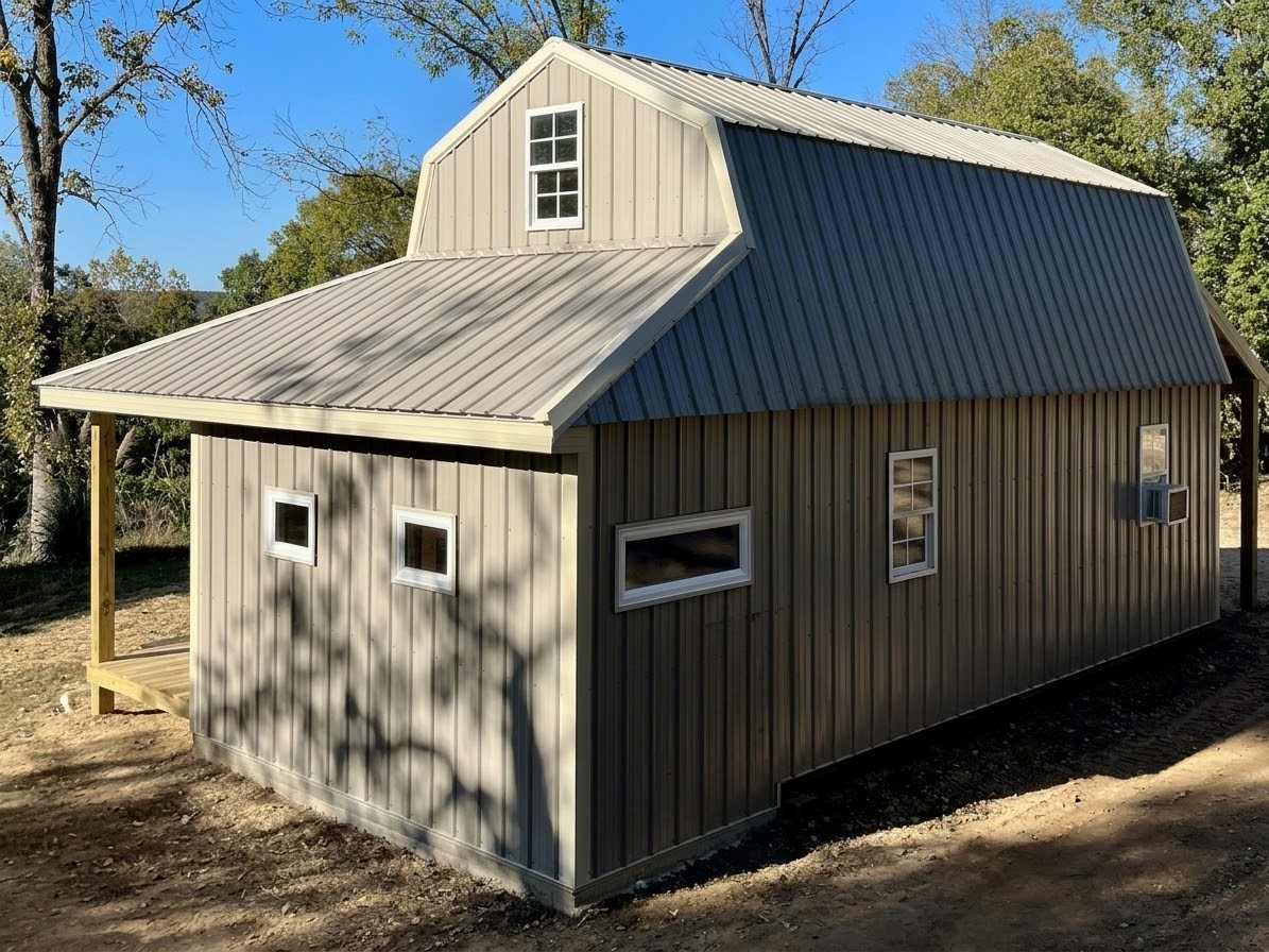 Bathroom addition with metal siding, gambrel roof and covered porch, built onto an existing shed